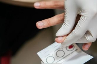 Exame de sangue com amostra sendo coletada para análise laboratorial.