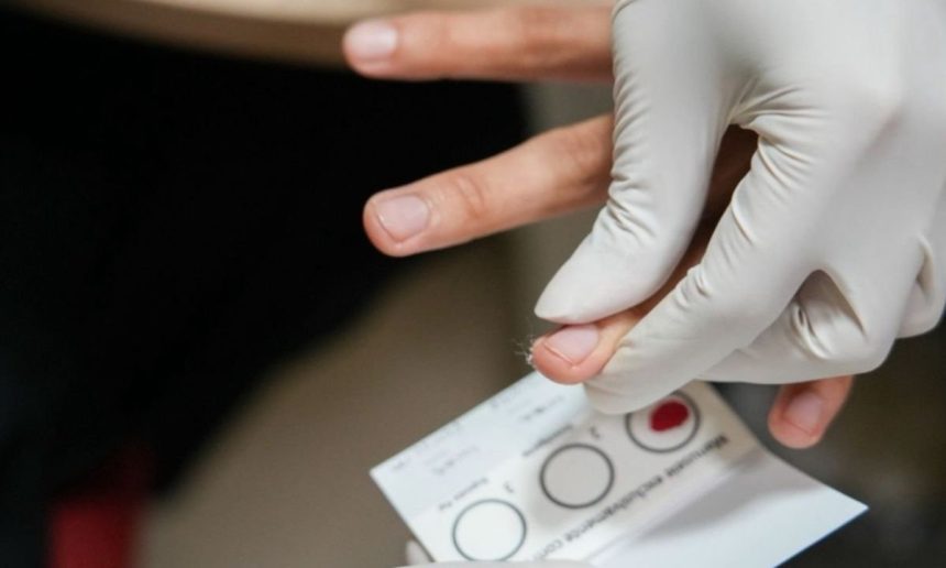 Exame de sangue com amostra sendo coletada para análise laboratorial.