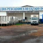 Fachada da Fepesca, Federação dos Pescadores do Estado do Amazonas, com veículos e área externa.