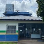 Fachada de delegacia de polícia, com antenas e reservatório de água no telhado.