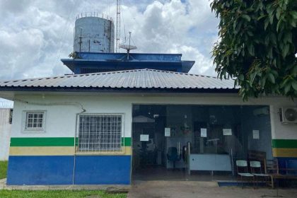 Fachada de delegacia de polícia, com antenas e reservatório de água no telhado.