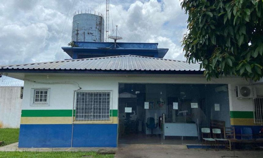Fachada de delegacia de polícia, com antenas e reservatório de água no telhado.