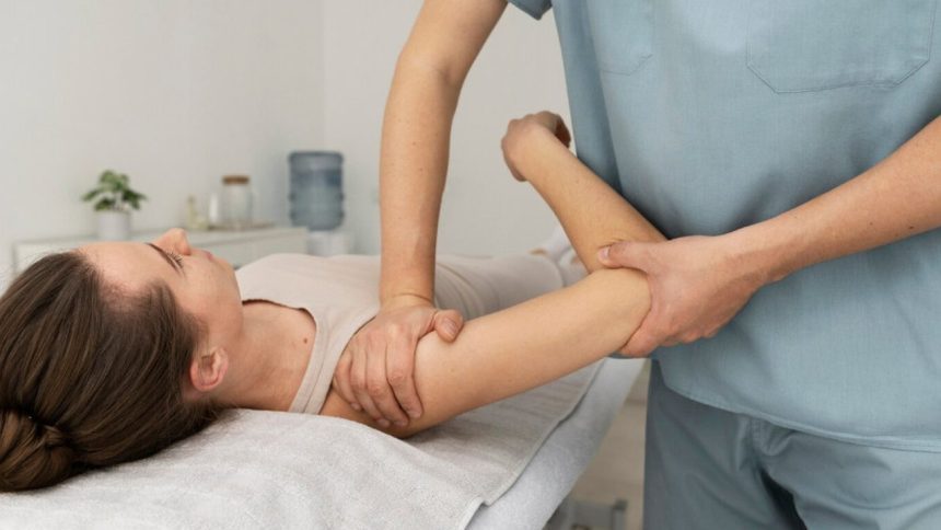 Fisioterapeuta realizando massagem no braço de paciente para aliviar dores.