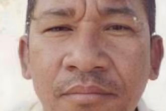 Foto de um homem com expressão séria, possivelmente um retrato.