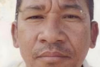 Foto de um homem com expressão séria, possivelmente um retrato.