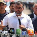 Governador discursa em entrega de viaturas, com oficiais e jornalistas presentes.