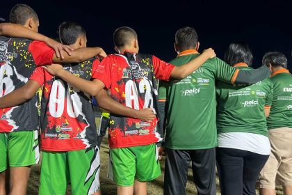 Grupo de pessoas com camisas de times de futebol abraçados, mostrando apoio e união. Taça das Favelas
