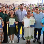 Wilson Lima e Grupo de pessoas posando para foto segurando documentos, com um grande público ao fundo.
