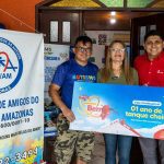 Grupo de pessoas segura vale combustível '01 ano de tanque cheio' da Atem, em apoio à Associação de Amigos do Autista.