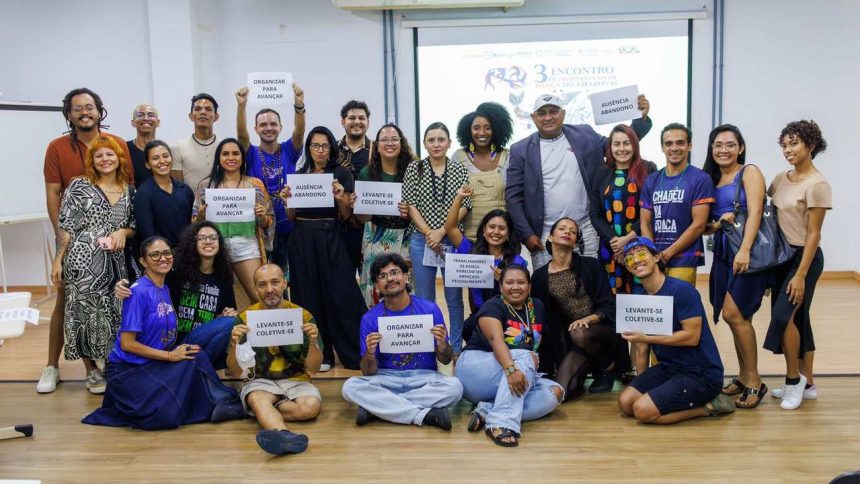 Grupo de pessoas segurando cartazes em evento sobre dança em Manaus.