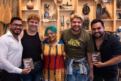 Grupo de pessoas sorrindo com livros, em evento de oficinas gratuitas 'Aglomeração Literária' no Amazonas.
