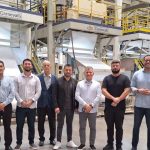 Grupo em fábrica da GLA com máquinas de produção