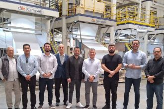 Grupo em fábrica da GLA com máquinas de produção