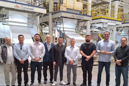 Grupo em fábrica da GLA com máquinas de produção