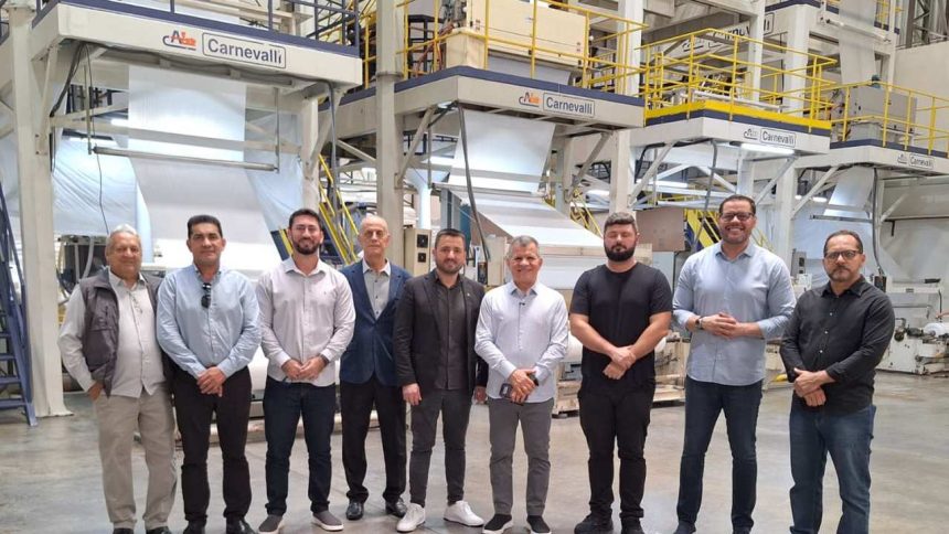 Grupo em fábrica da GLA com máquinas de produção