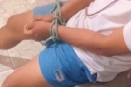 Homem amarrado sendo resgatado pela polícia.