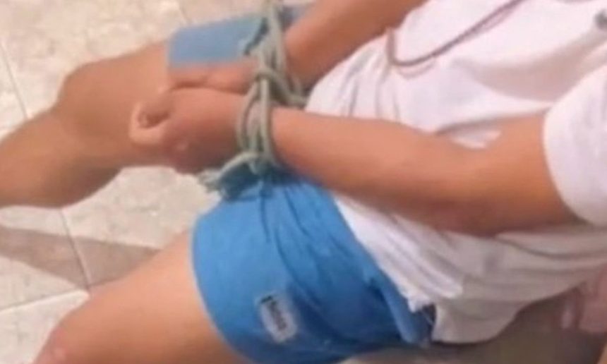 Homem amarrado sendo resgatado pela polícia.