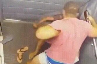 Homem em camisa rosa agrediu outra pessoa em espaço interno.