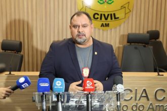 Homem fala em coletiva de imprensa sobre Operação Shamar com microfones à frente.