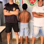 Homem preso em Juruá, Amazonas, suspeito de agressão à esposa, cercado por policiais.