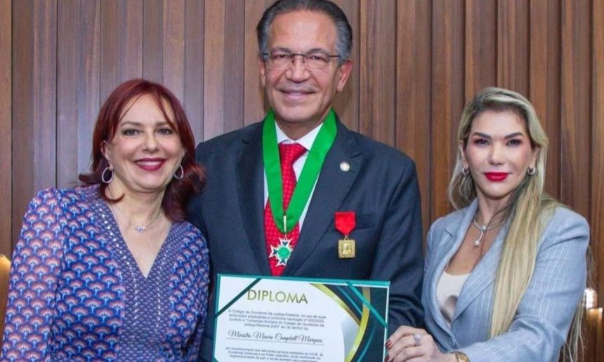 Homem recebe diploma ladeado por duas mulheres, celebrando sua dedicação à Justiça.