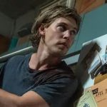 Homem segurando um taco de beisebol, possivelmente em um filme.