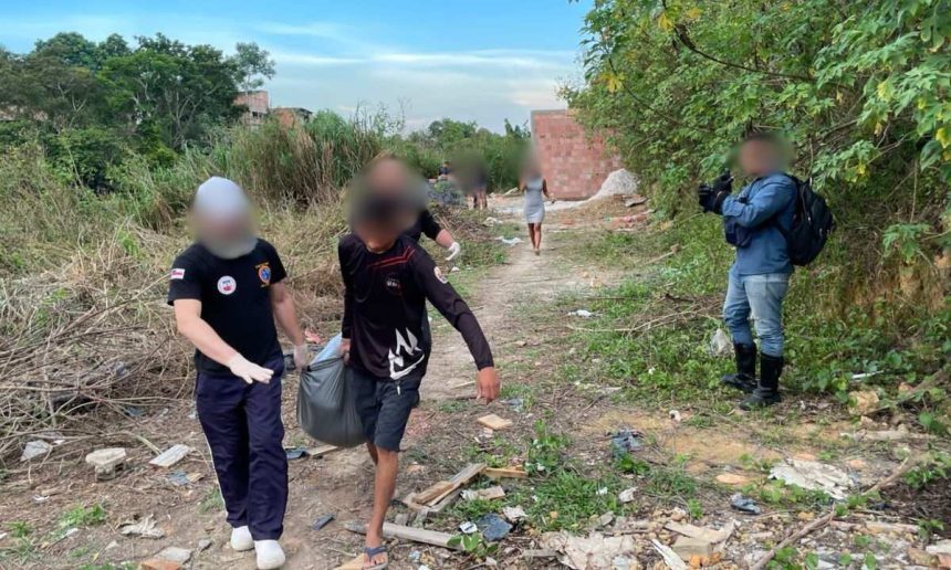 Homens carregam corpo em construção abandonada, em notícia sobre achado.