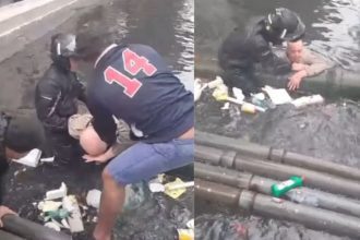 Idoso sendo resgatado em enchente por populares em Santos