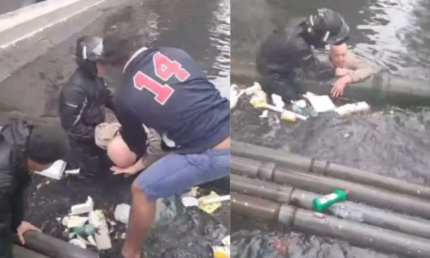 Idoso sendo resgatado em enchente por populares em Santos