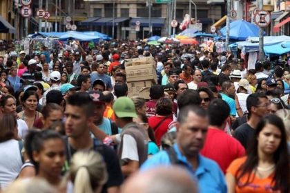 Imagem de multidão em rua comercial, possivelmente em Manaus.