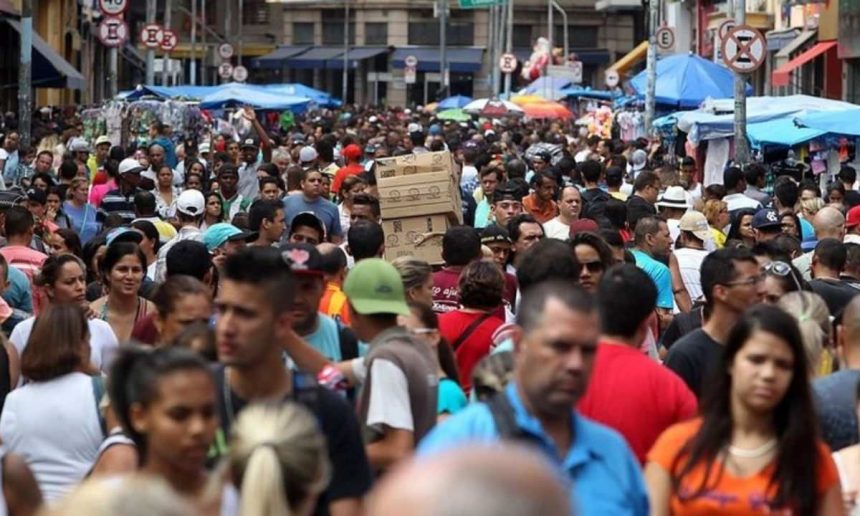 Imagem de multidão em rua comercial, possivelmente em Manaus.