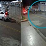 Imagem mostra três homens correndo em via pública à noite, com carro e moto estacionados.