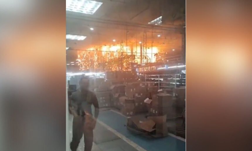 Incêndio em fábrica: funcionários correm em meio às chamas e fumaça.