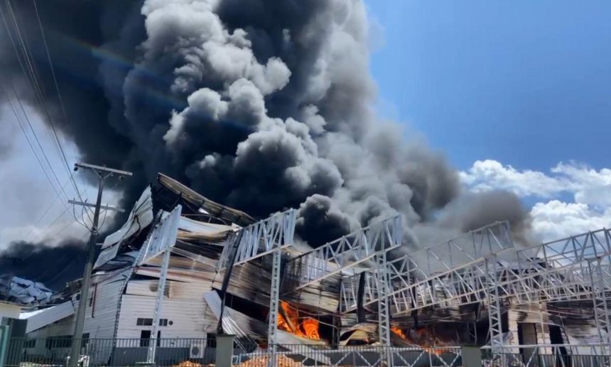 Incêndio em fábrica no Distrito Industrial II, com densa fumaça preta e fogo.