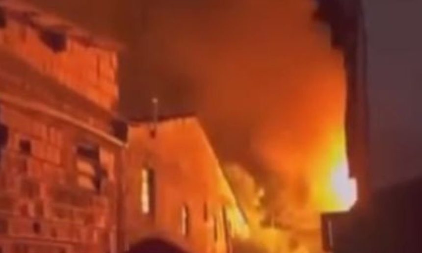 Incêndio em residência com chamas alaranjadas e fumaça densa.