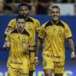 Jogadores do Amazonas FC comemoram em campo, uniformizados com camisas amarelas