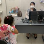 Mãe e criança em consulta médica, com médica usando máscara, contexto de aumento de casos de SRAG/Covid-19.