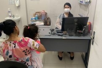Mãe e criança em consulta médica, com profissional usando máscara.
