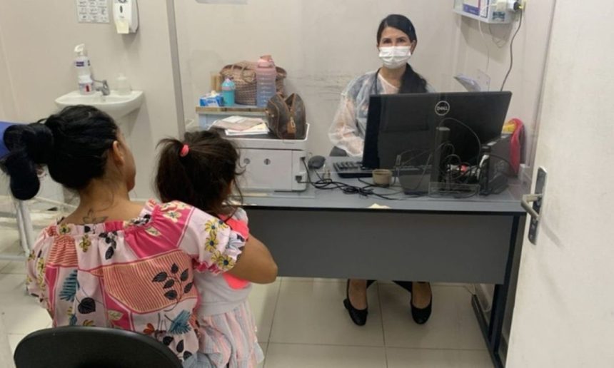 Mãe e criança em consulta médica, com profissional usando máscara.