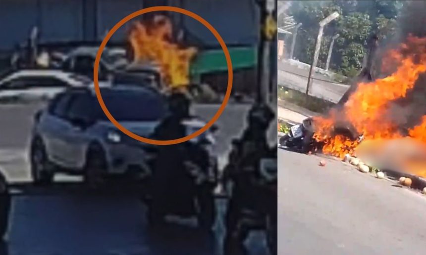 Motocicleta em chamas após acidente trágico, com bombeiros e carro nas proximidades.