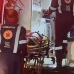 Mulher em maca sendo socorrida por equipe do SAMU dentro de ambulância.