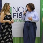 Mulheres em evento com microfone. Ao fundo, logo 'Nota Fiscal Amazon'.