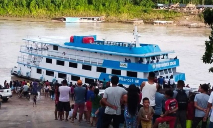 Navio do INSS atracado para atendimento móvel na região amazônica, com pessoas reunidas no local.