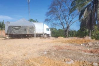 Obra de aterro irregular embargada pelo Ipaam, com tenda, caminhão e terreno.