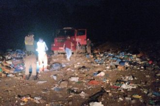 Operação do Ibama em área de descarte de lixo à noite, com equipe e caminhão.