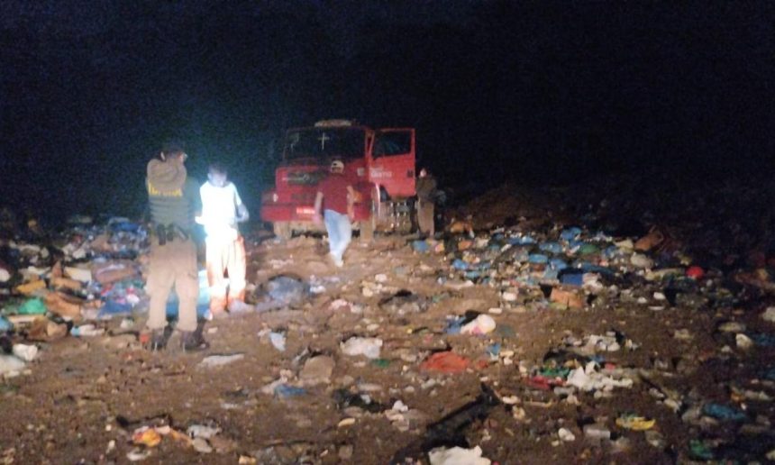 Operação do Ibama em área de descarte de lixo à noite, com equipe e caminhão.