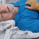 Paciente idoso em leito hospitalar, buscando familiares no Hospital João Lúcio, Amazonas.