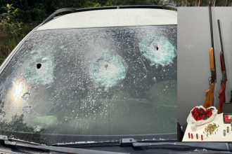 Para-brisa de carro com marcas de tiros e armas apreendidas.