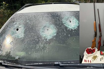 Para-brisa de carro com marcas de tiros e armas apreendidas.