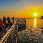 Pessoas apreciando o pôr do sol em Manaus, com um dia quente de 35°C.